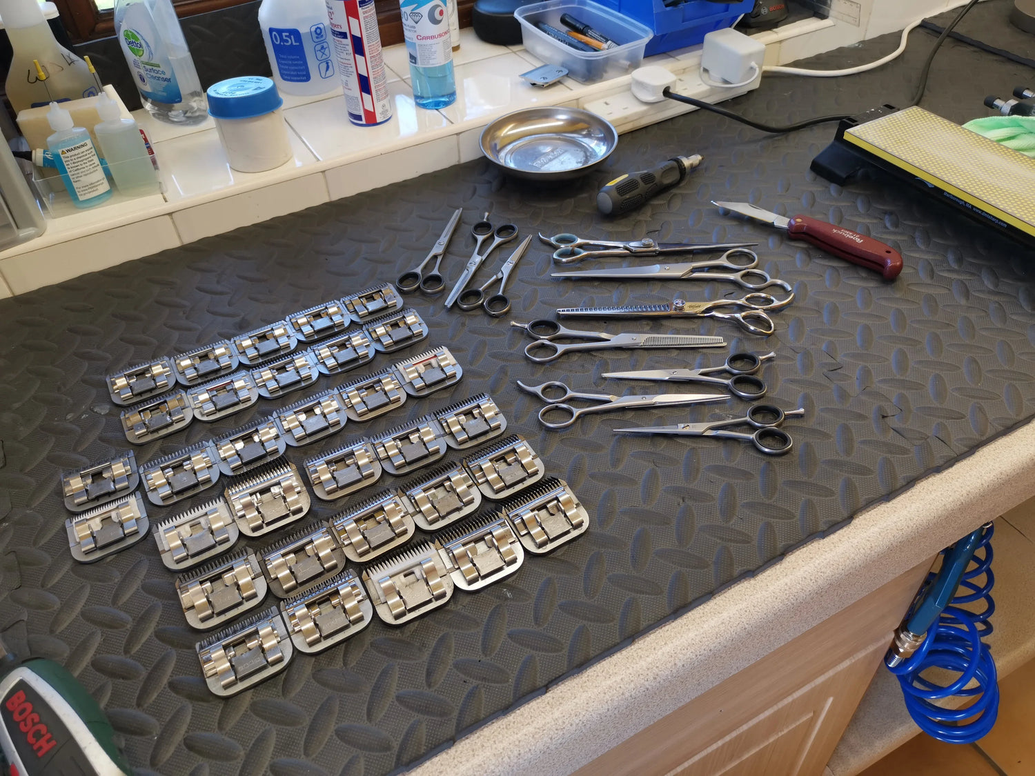 Set of dental tools including pliers, scissors, and metal instruments on a textured surface.