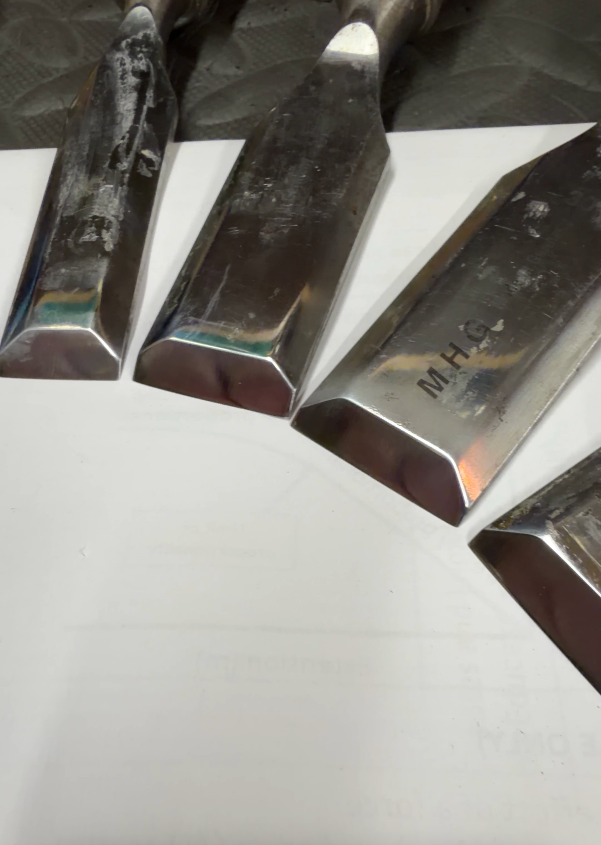 Metal chisels on a white surface with a blurred background