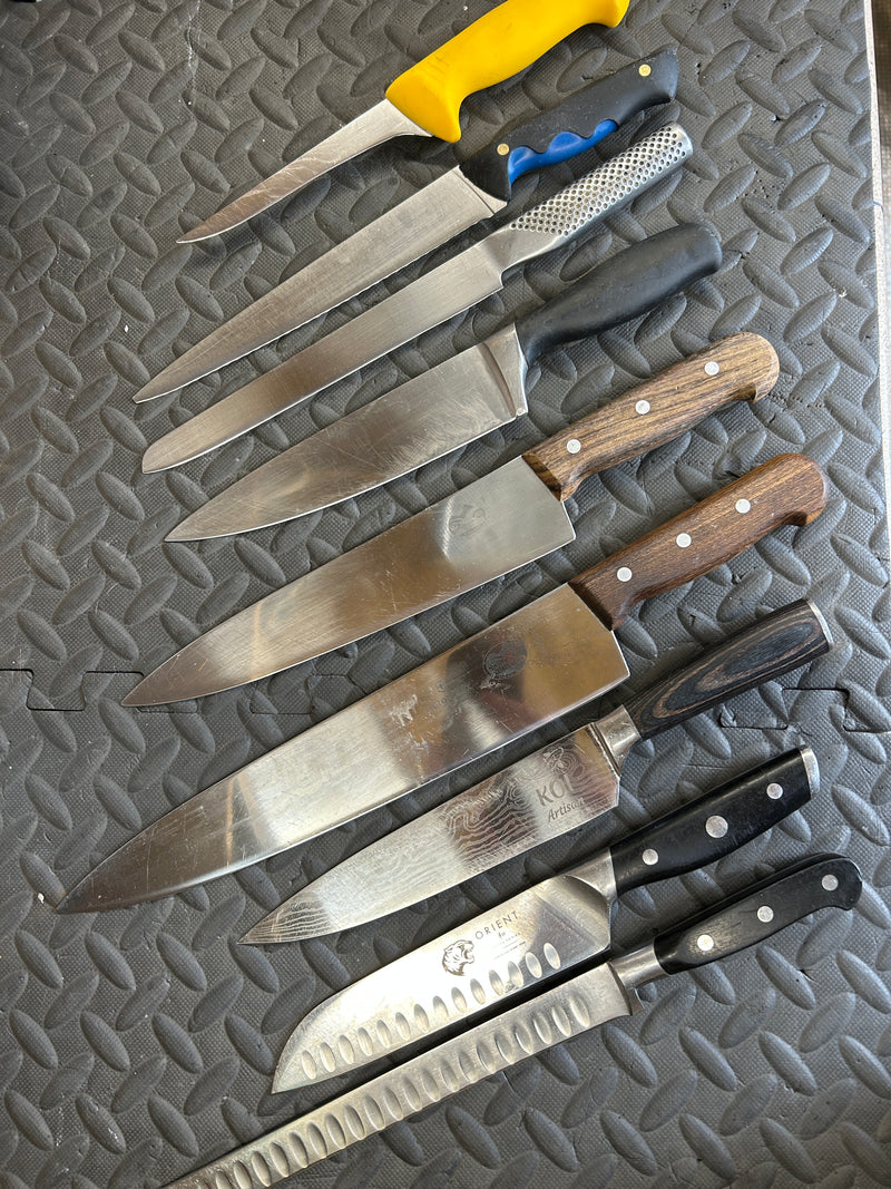 Set of knives with various handles on a textured surface